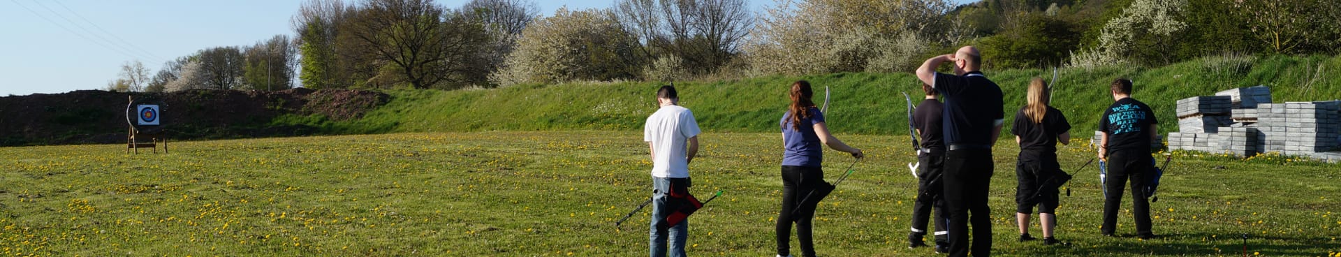Bogenschützen mit Pfeil und Bogen auf der grünen Wiese vor den Zielscheiben